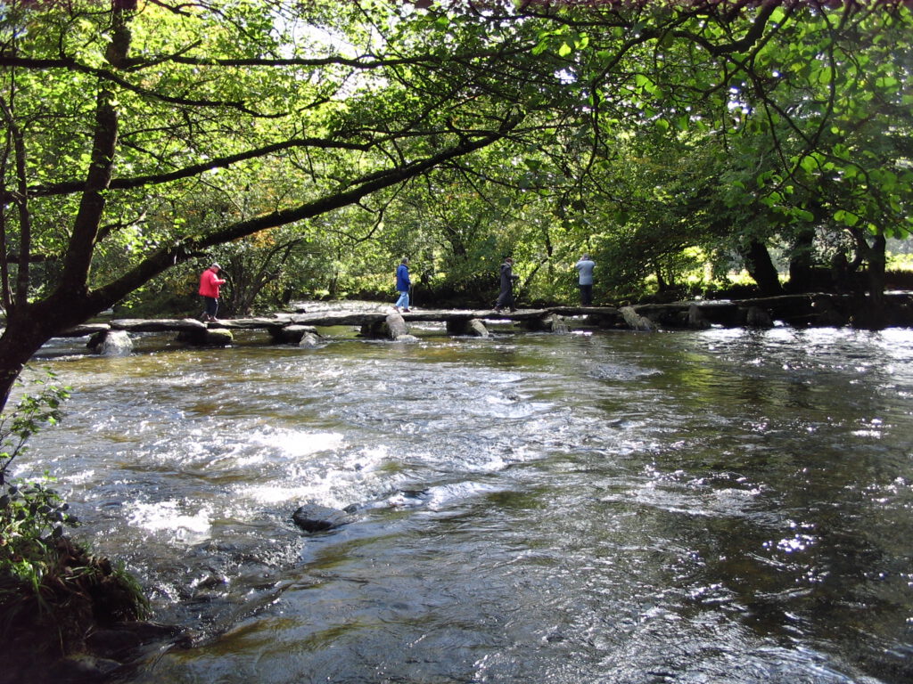 Das Foto zeigt die Brücke Tarr Steps von der Seite. Bei Hochwasser werden die ein bis zwei Tonnen schweren Platten der Tarr Steps schon einmal weggerissen